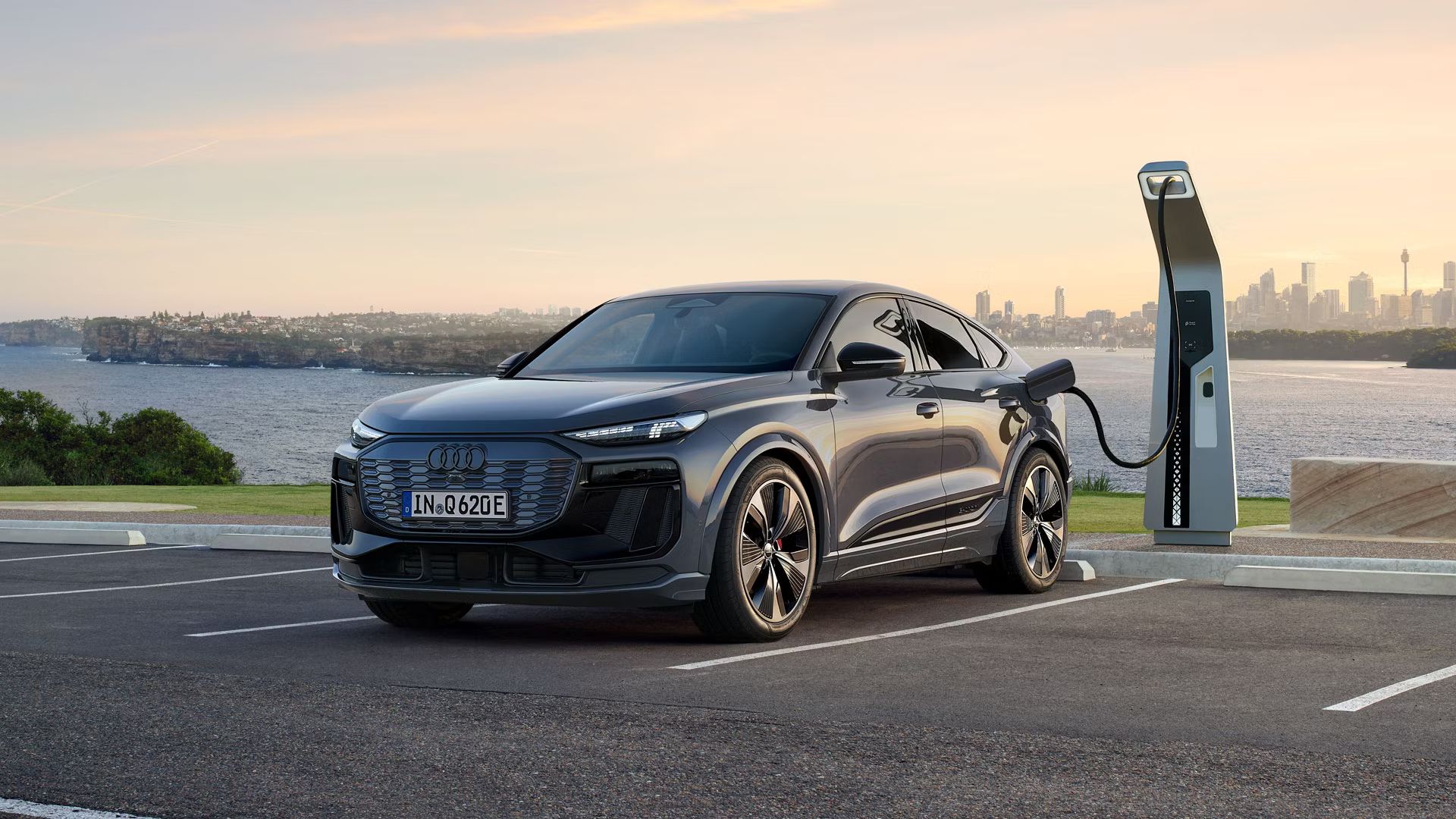 Audi Q6 je zaparkované na parkovacom mieste pri nabíjacej stanici na pobreží.