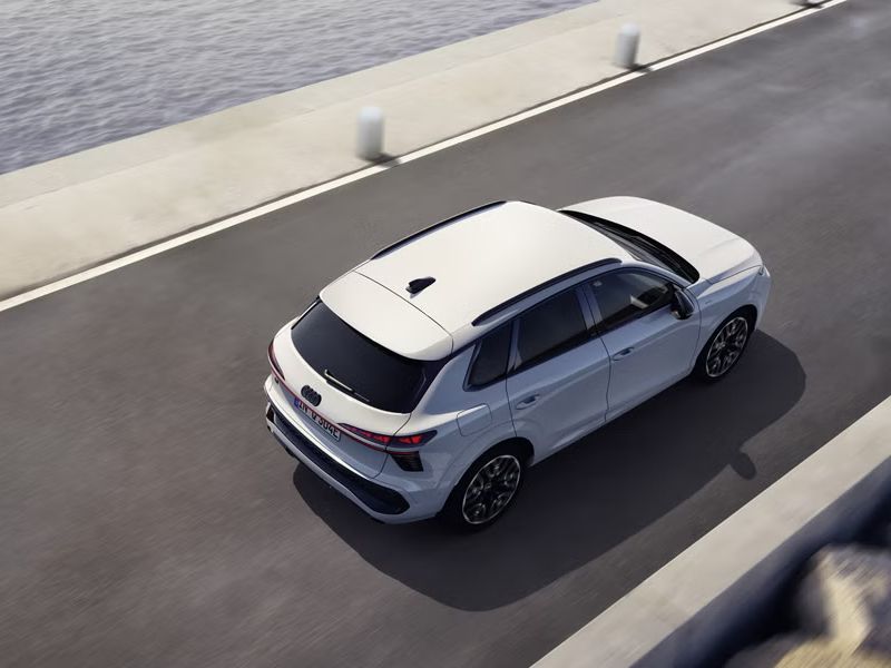 SUV Q3 e-hybrid jazdí po ceste, ktorá vedie paralelne s morom.