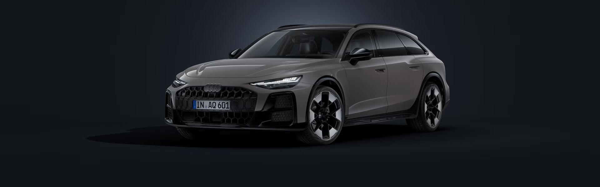 Audi A6 allroad v šikmom pohľade spredu na tmavom pozadí.