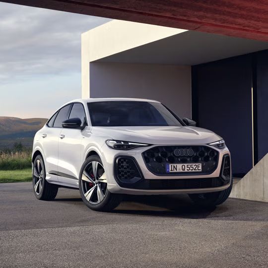 Pohľad na predné partie Audi Q5 Sportback e-hybrid pred modernou vilou.