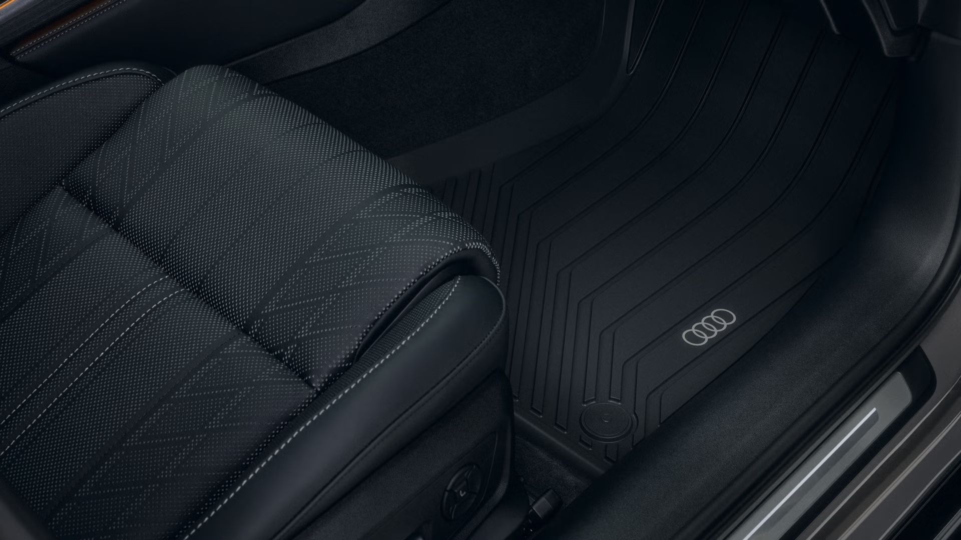 Detailný záber na priestor pre nohy na strane spolujazdca v modeli Audi A6 allroad s rohožou do každého počasia.