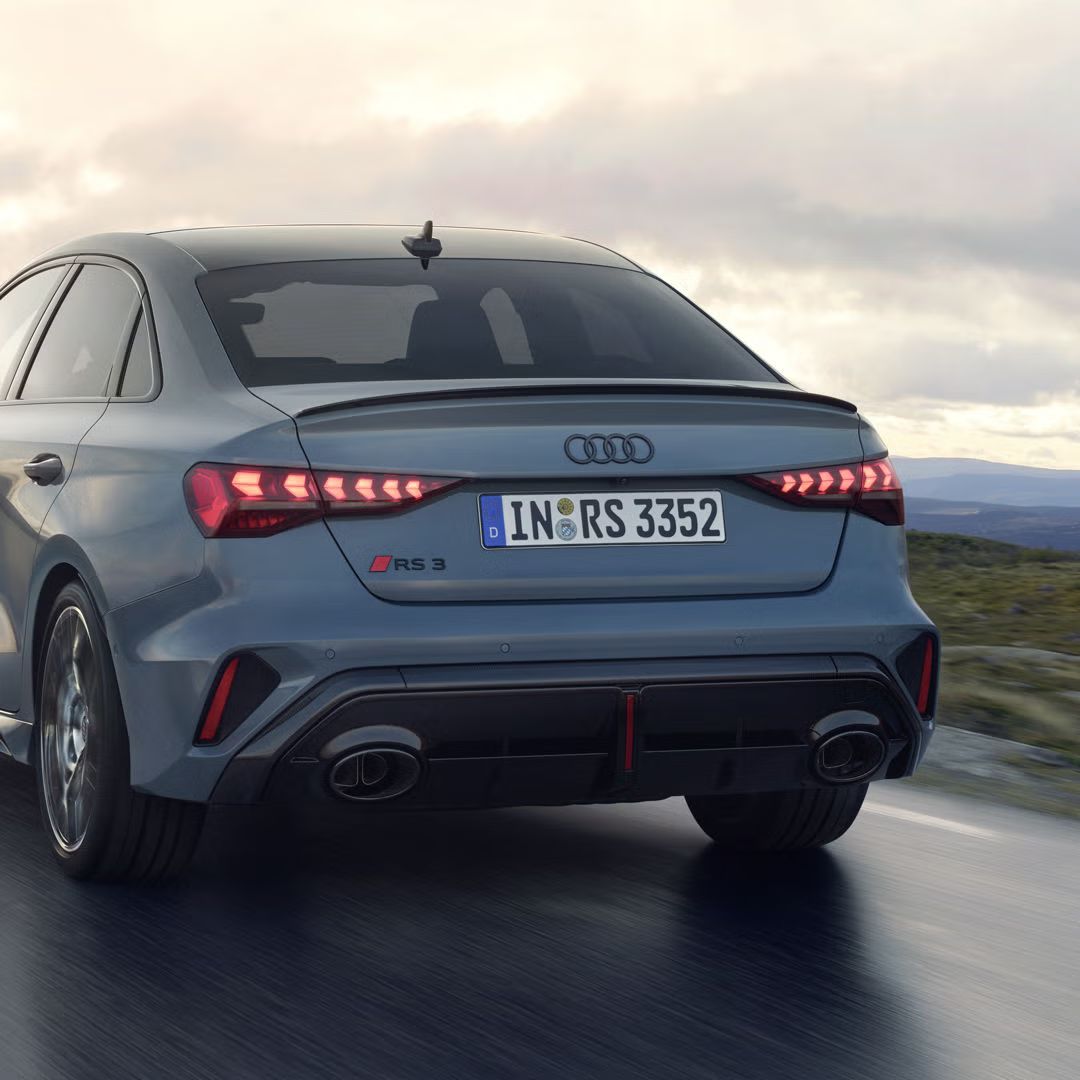 Audi RS 3 Limuzína jazdí po horskej ceste za zamračeného počasia.