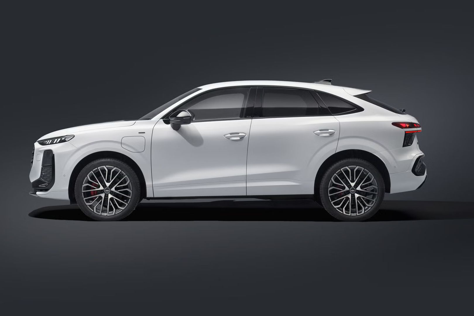 Audi Q3 Sportback e-hybrid z bočného pohľadu v tmavom prostredí.