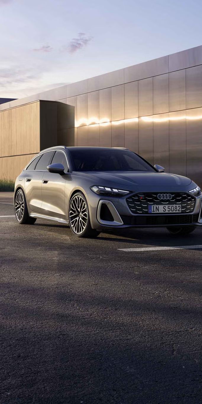 Der S5 Avant steht auf einem Parkplatz vor einem Gebäude, schräg von vorn fotografiert.