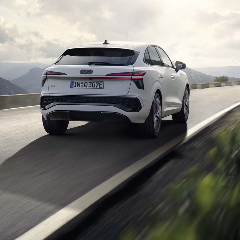 Biely Q3 Sportback e-hybrid ide po ceste v horskej krajine.	