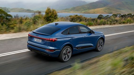 Seitliche Heckansicht eines fahrenden, blauen Audi SQ6 Sportback e-tron