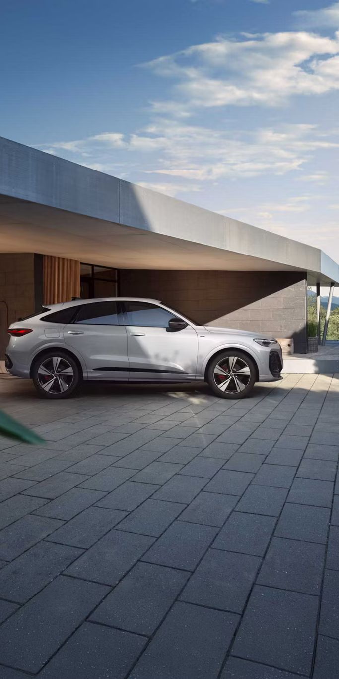 Audi Q5 Sportback e-hybrid Seitenansicht vor einem Haus