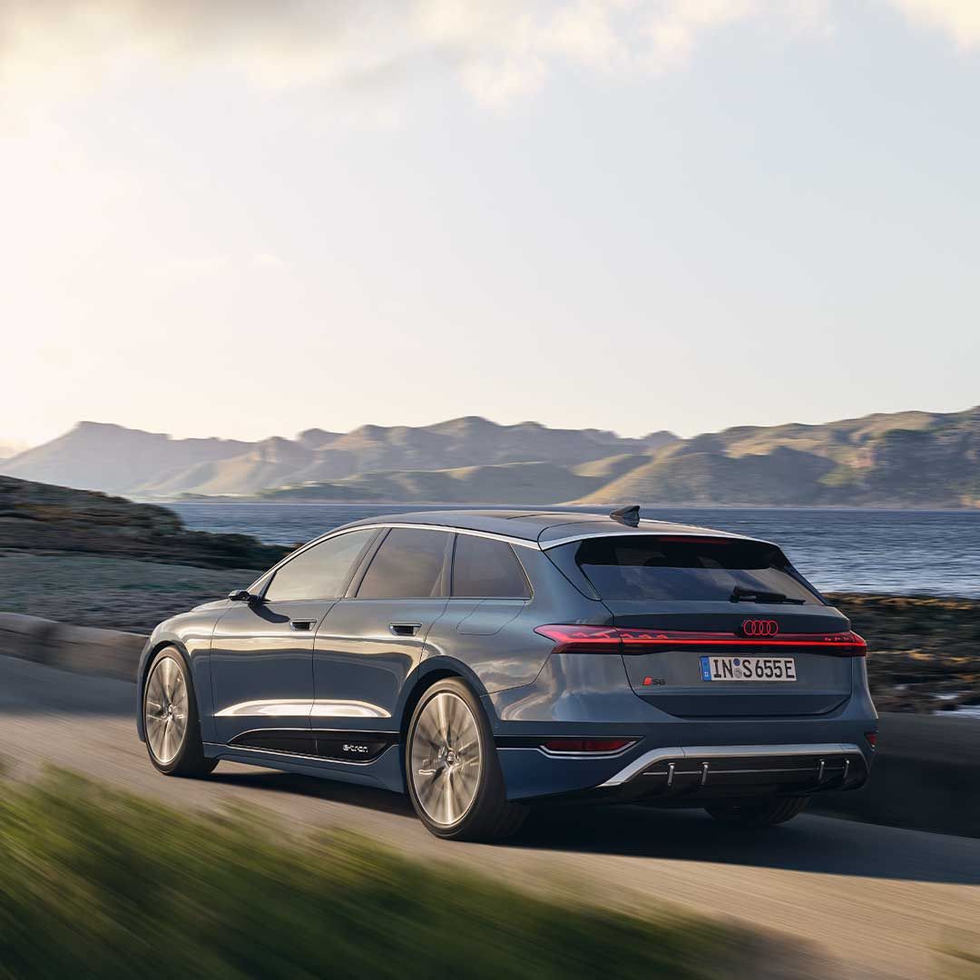 Pohľad na Audi S6 Avant e-tron počas dynamickej jazdy na ceste popri pobreží.