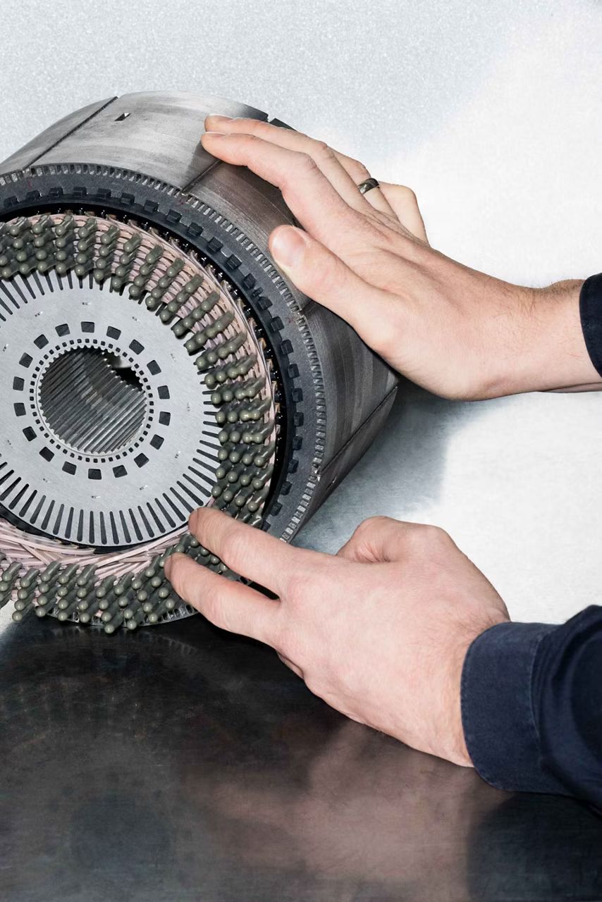 Detail na súčiastku, ktorú držia dve ruky.