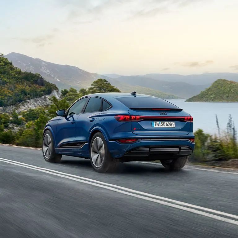 Audi SQ6 Sportback e-tron počas jazdy po ceste v kopcoch v zálive.