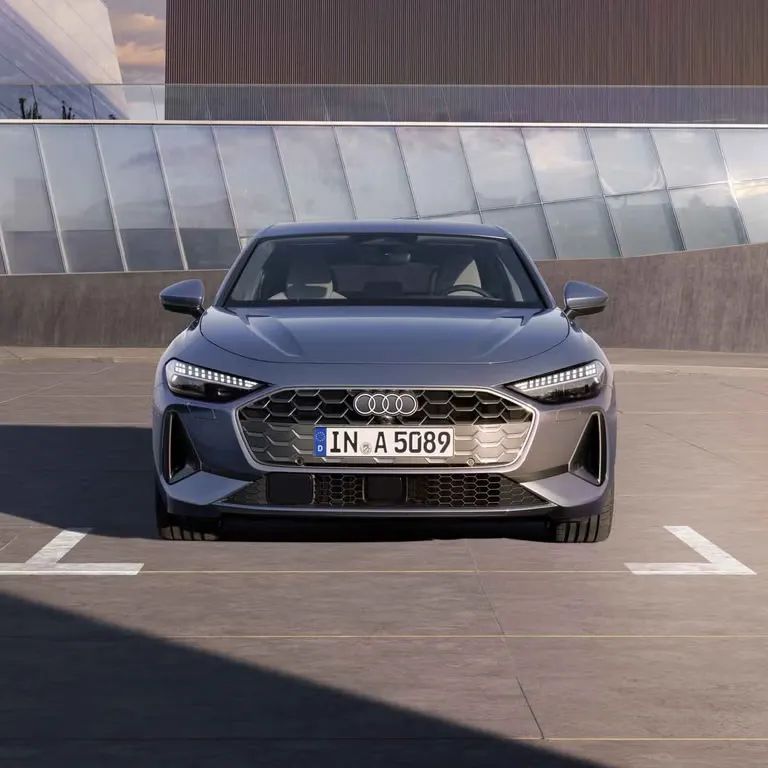 Audi A5 Limuzína stojí na parkovacom mieste parkoviska pri modernej, verejnej budove.