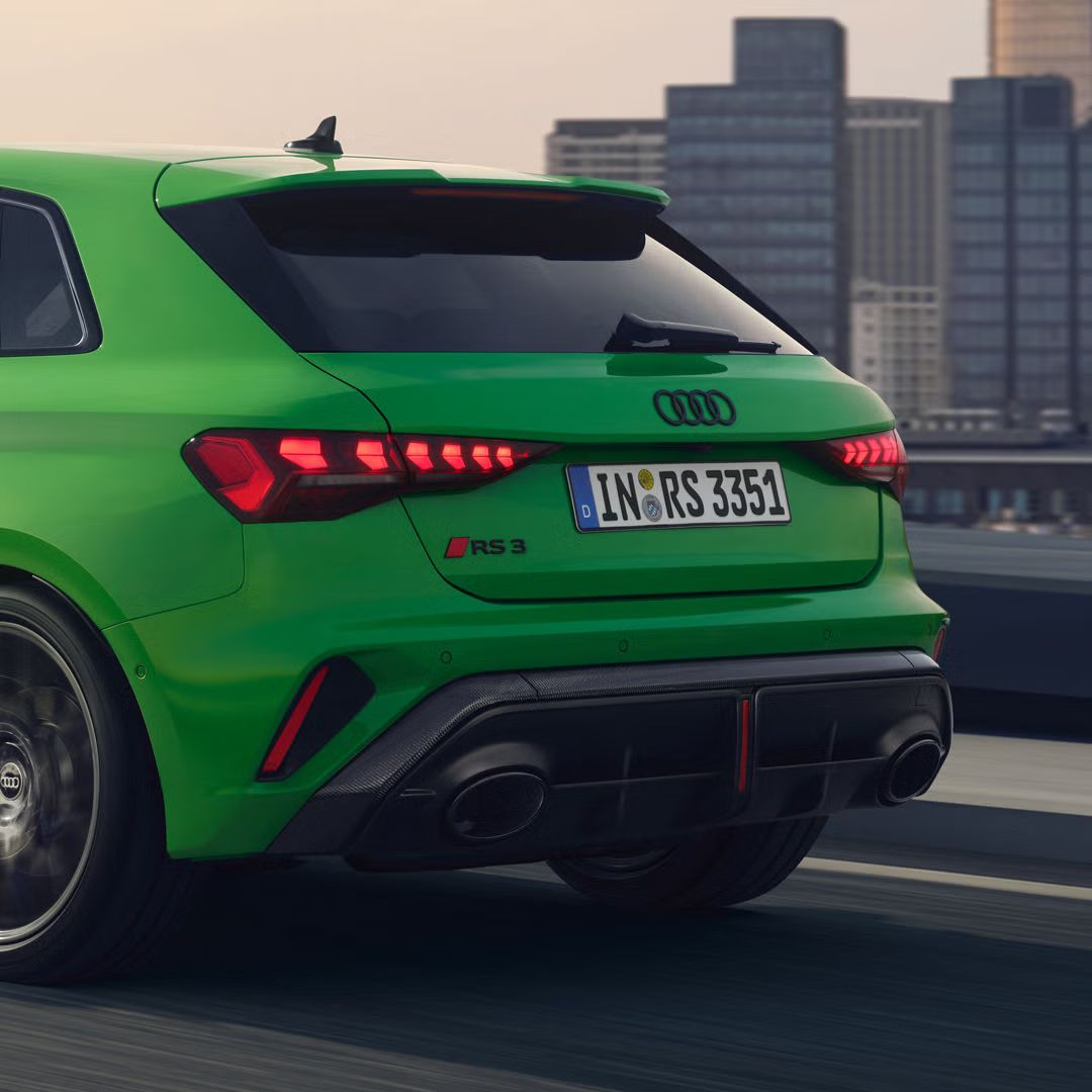 Detailný záber na zadnú časť modelu RS 3 Sportback z bočného pohľadu zo zadnej strany, v pozadí je panoráma mesta.