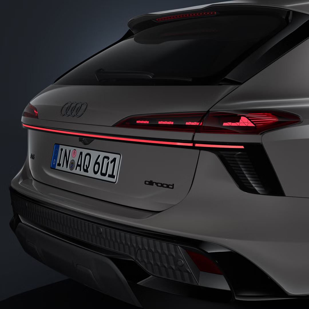 Detailný záber na zadnú časť vozidla Audi A6 allroad so zadnými svetlami a svetelným pásom zo šikmého pohľadu.