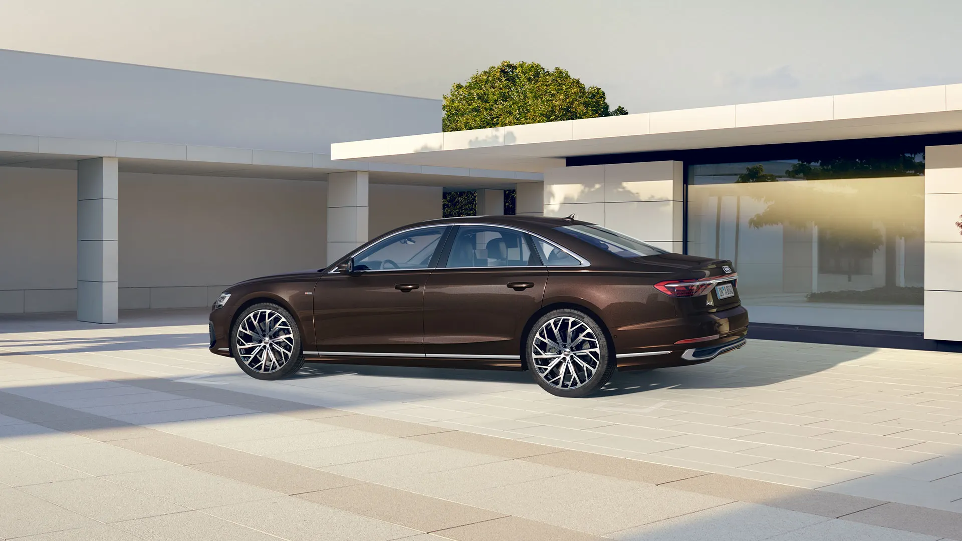 Audi A8 z bočného pohľadu zaparkovaný pri vile.