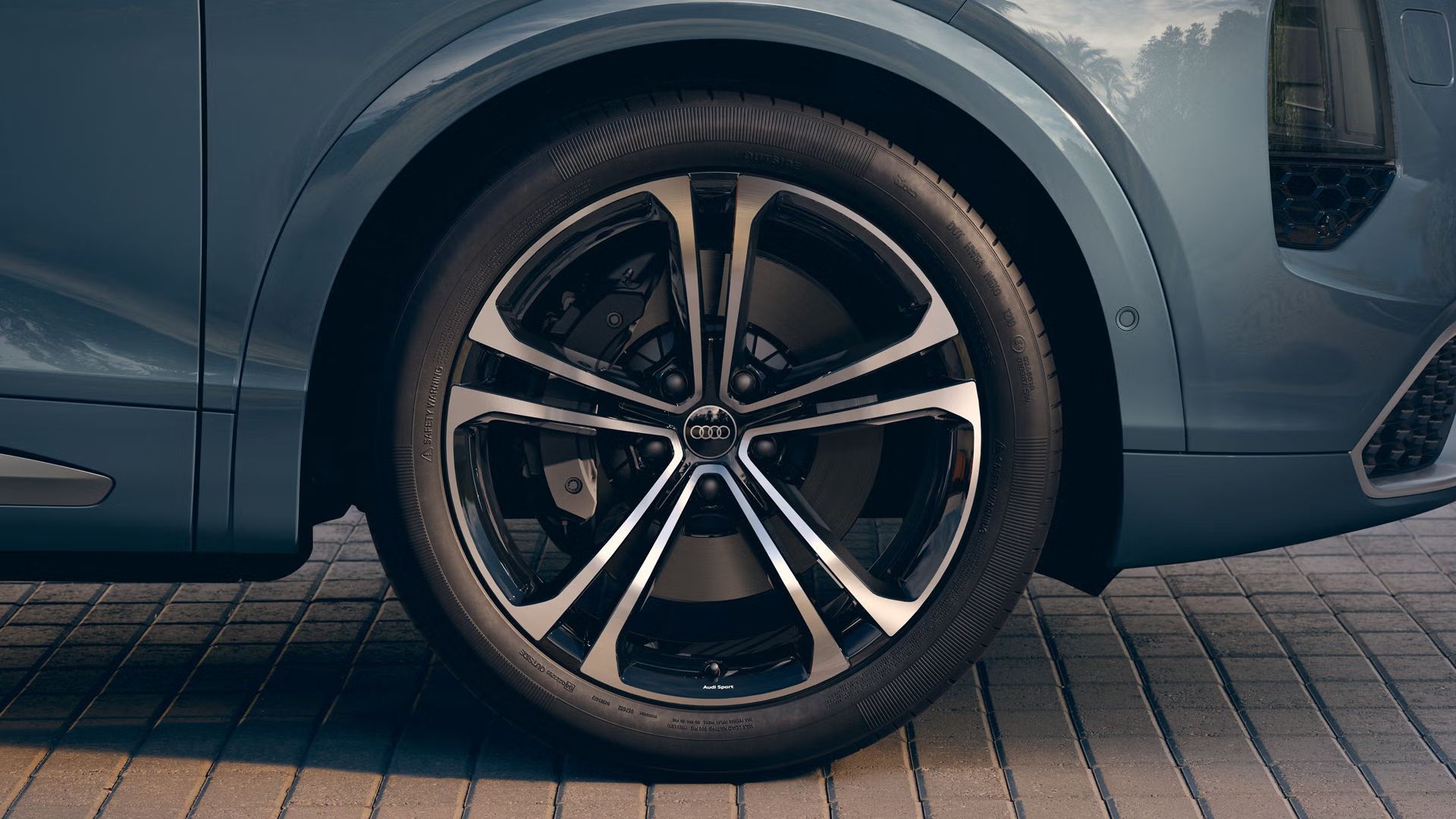Detailný záber na koleso Audi s 22-palcovým viaclúčovým diskom z ľahkej zliatiny Audi Sport v dizajne S v čiernej metalíze.