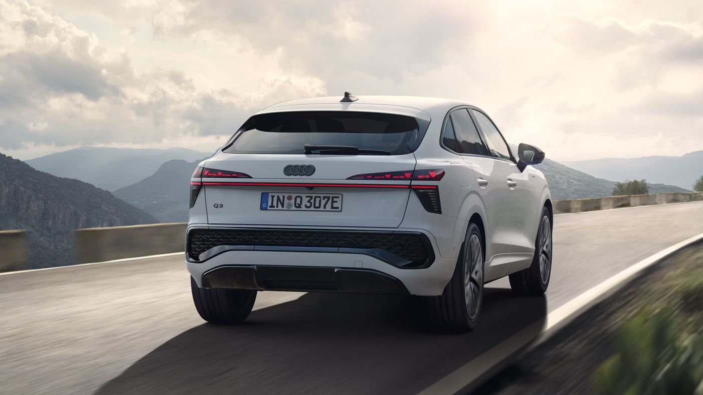 Audi Q3 Sportback e-hybrid počas jazdy po vidieckej ceste v horách.