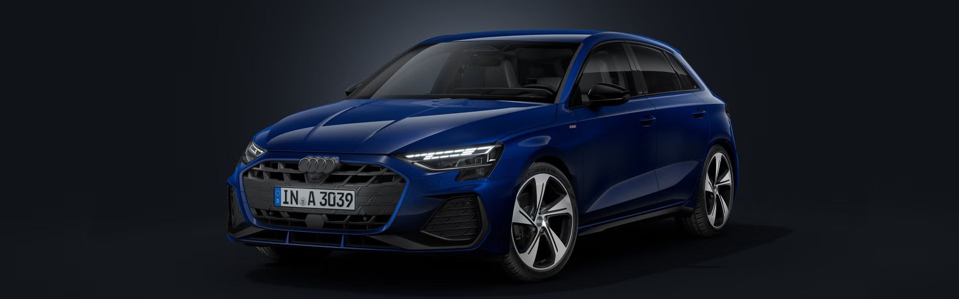 Audi A3 Sportback šikmo spredu na tmavom pozadí.