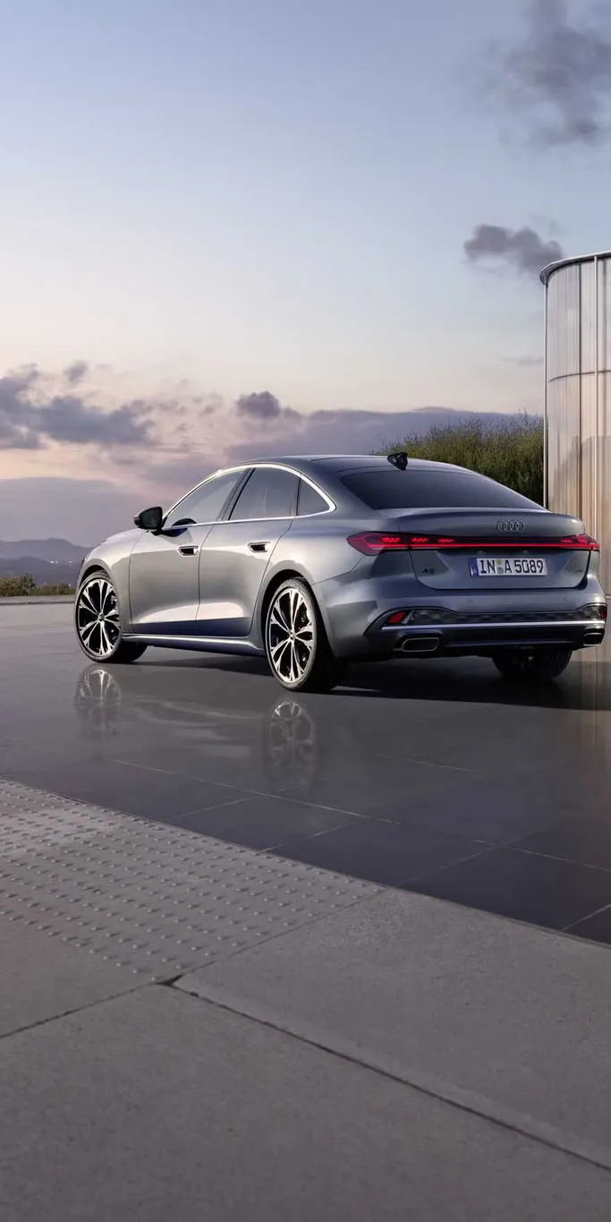 Bočný pohľad na zadnú časť sivého Audi A5 Limuzína.