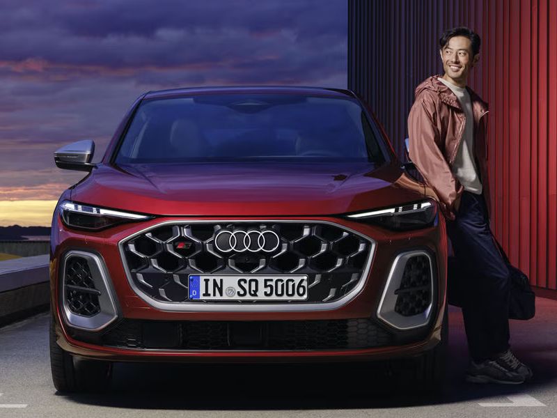 Pohľad na červené Audi SQ5 Sportback, o ktoré sa opiera muž