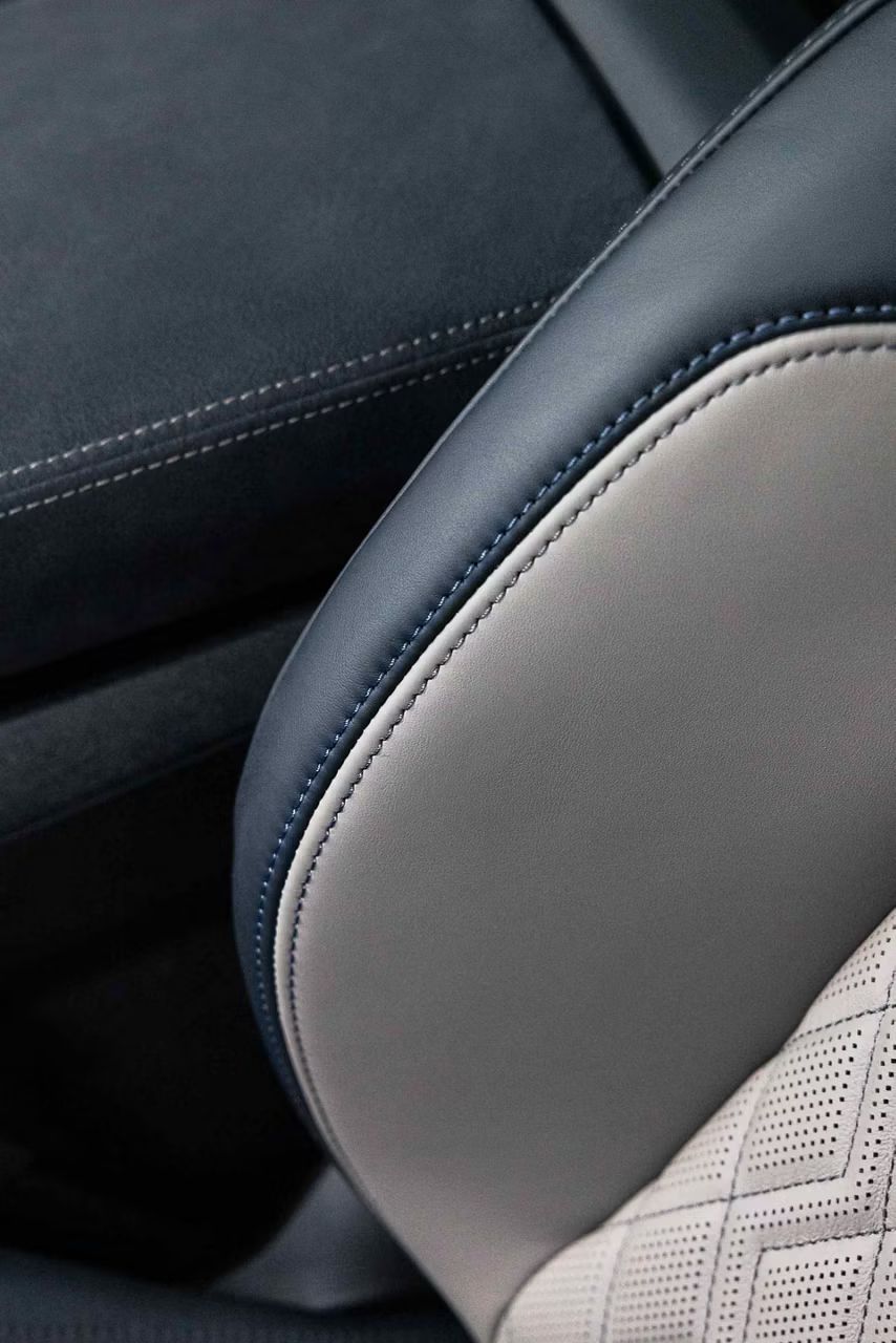 Detail na bok operadla predného sedadla sedadla čalúneného kožou v odtieňoch modrej a zlatej z divízie Audi exclusive.