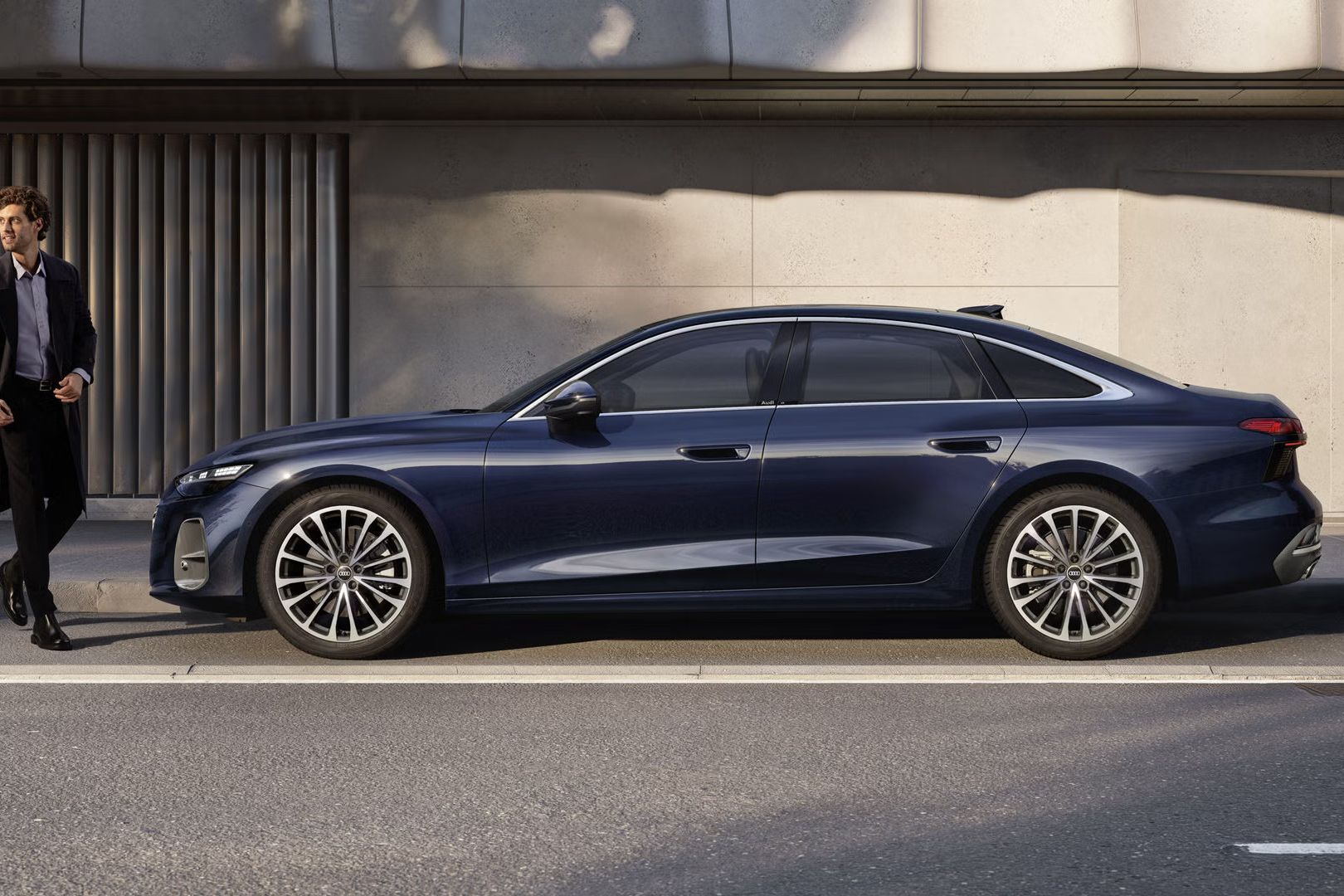 Modré Audi A6 Limuzína z bočného pohľadu zaparkované pri ceste vedľa modernej budovy.