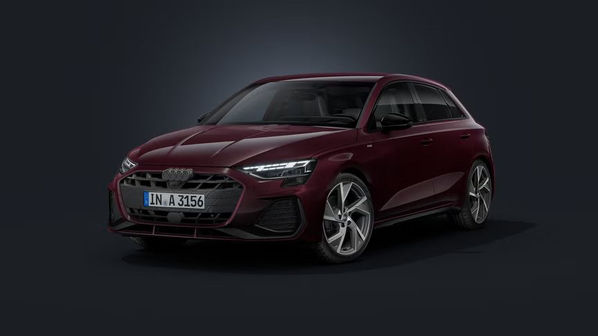 Audi A3 Sportback s individuálnym lakovaním Audi exclusive v odtieni Shirazrot Metallic, zobrazené z čelného pohľadu pod uhlom na tmavom pozadí.