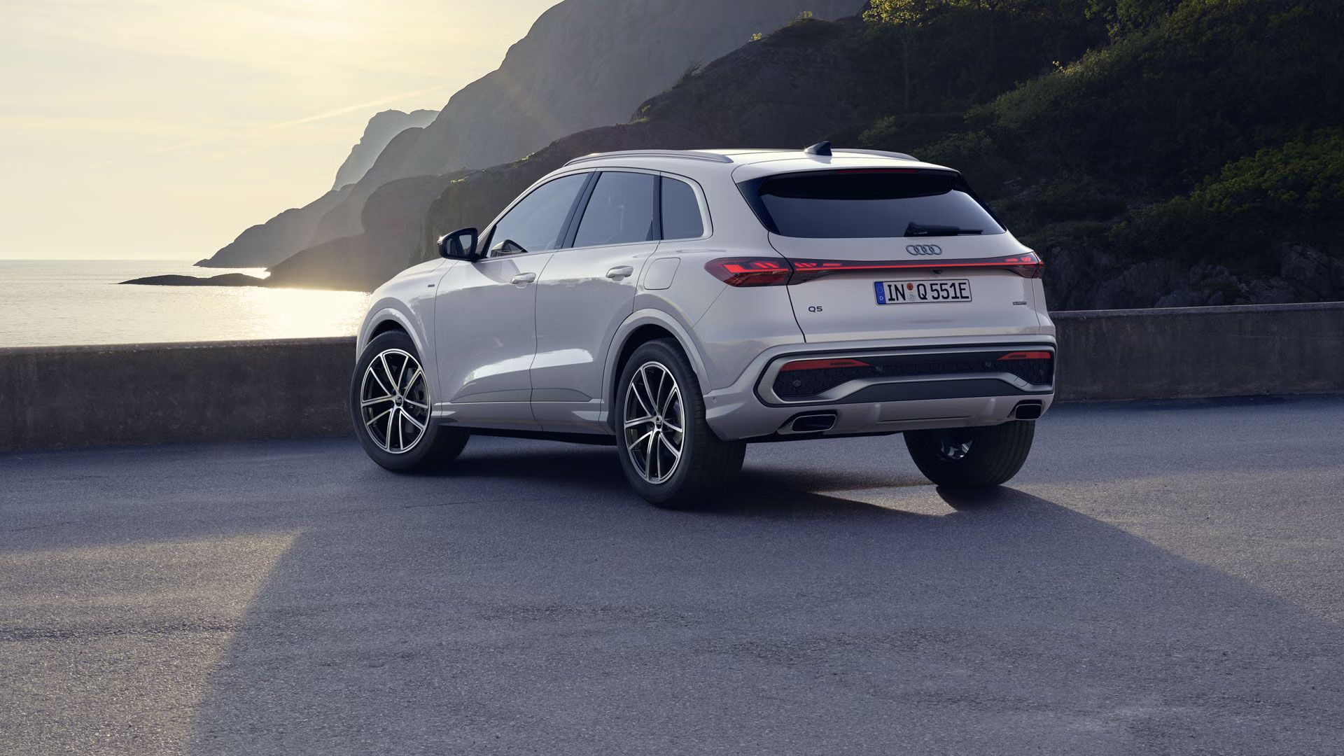 Biele Audi Q5 SUV e-hybrid stojí na parkovisku na pobreží.