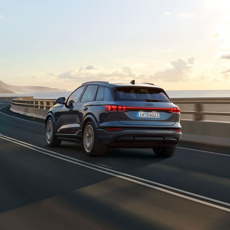Audi Q6 SUV e-tron počas jazdy na moste v zálive.