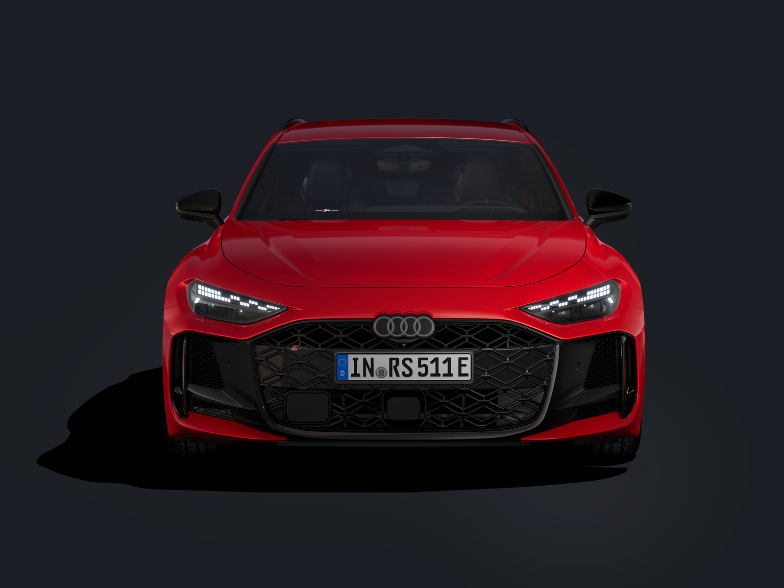 Červené Audi RS 5 Avant je zobrazené z čelného pohľadu na čiernom pozadí.