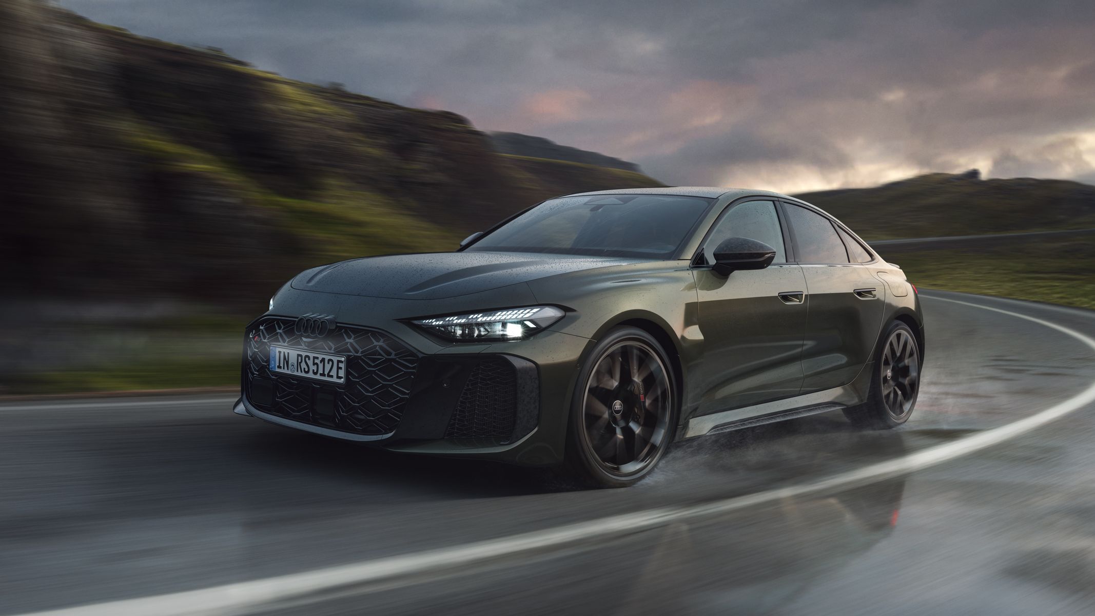 RS 5 Limuzína šikmo z prednej strany prechádza zákrutou na horskej ceste.