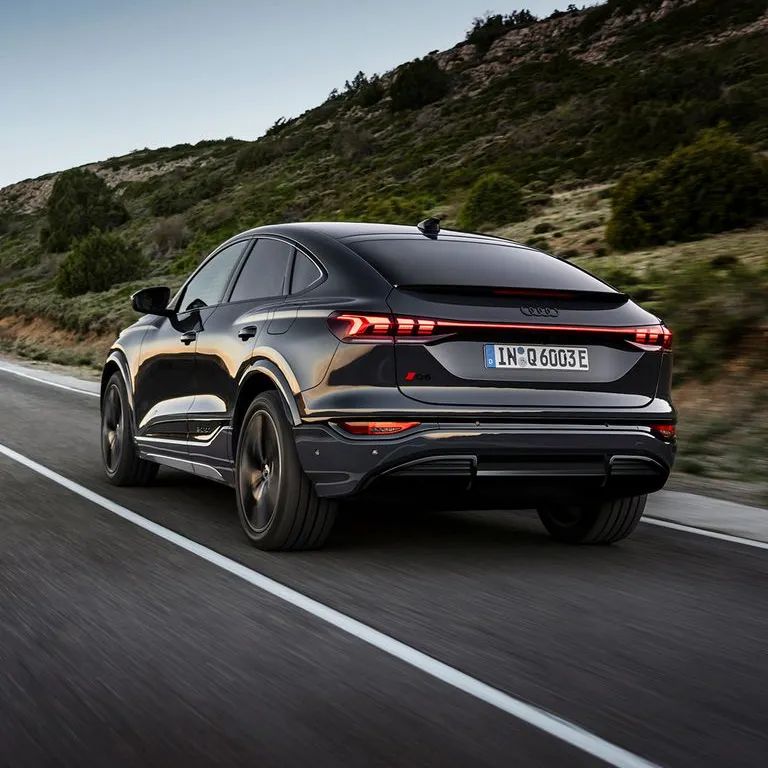 Audi Q6 Sportback počas jazdy po ceste v horskej krajine.