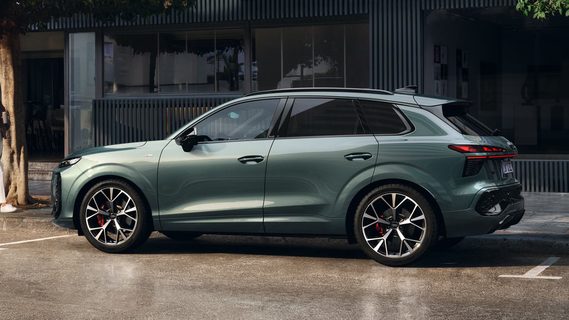 Audi Q3 SUV parkuje pred verejnou budovou.