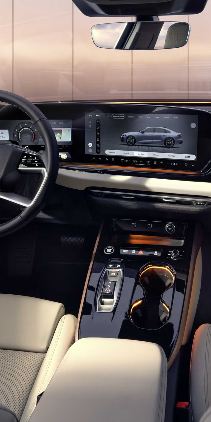 Blick von der Rückbank in das Cockpit der A5 Limousine. Zu sehen sind unter anderem die MMI Displays und das Lichtdesign mit dem Interaktionslicht am unteren Rand der Windschutzscheibe.