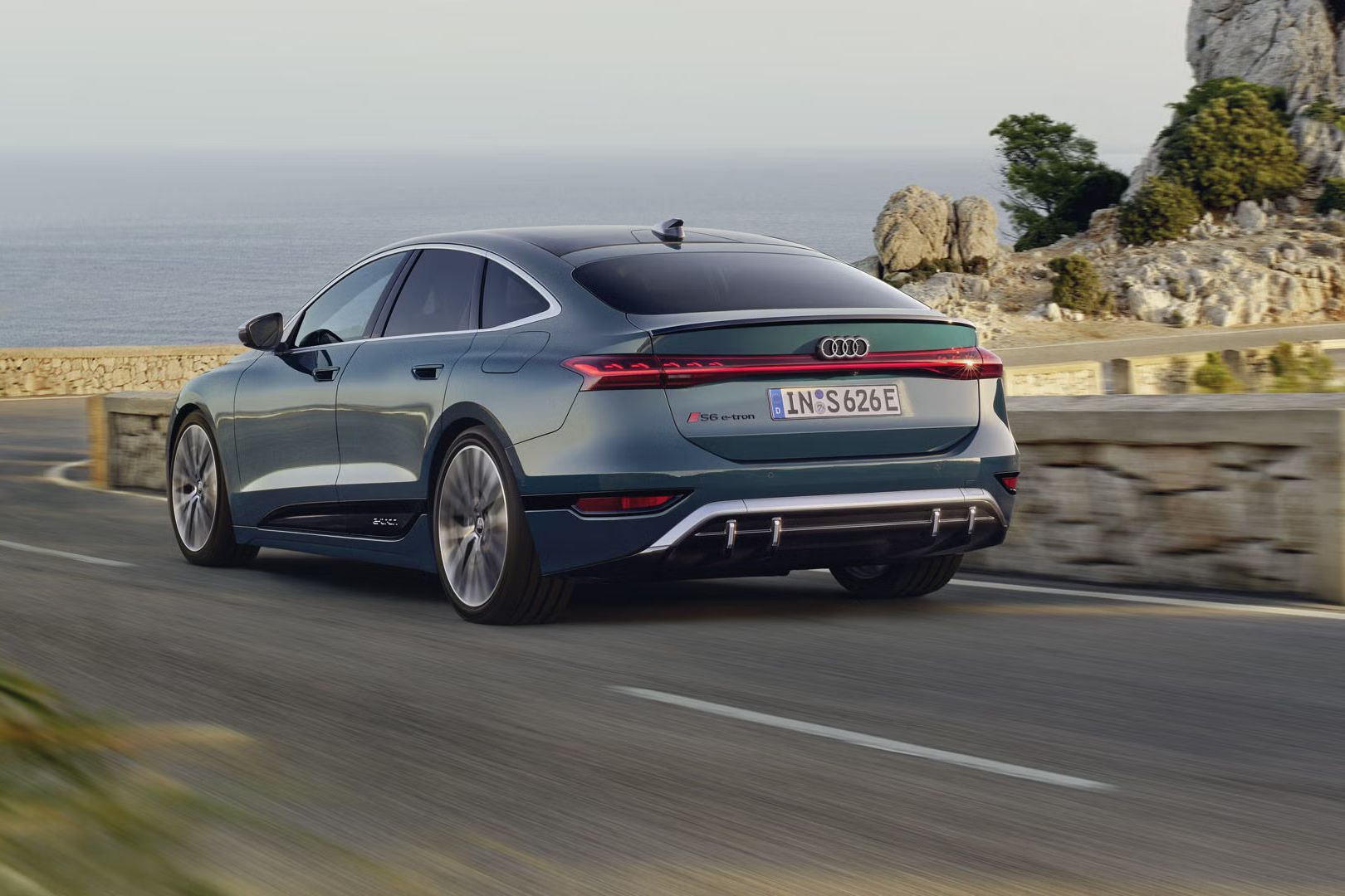 S6 Sportback e-tron v šikmom zadnom profile, zatiaľ čo jazdí po kľukatej pobrežnej ceste.