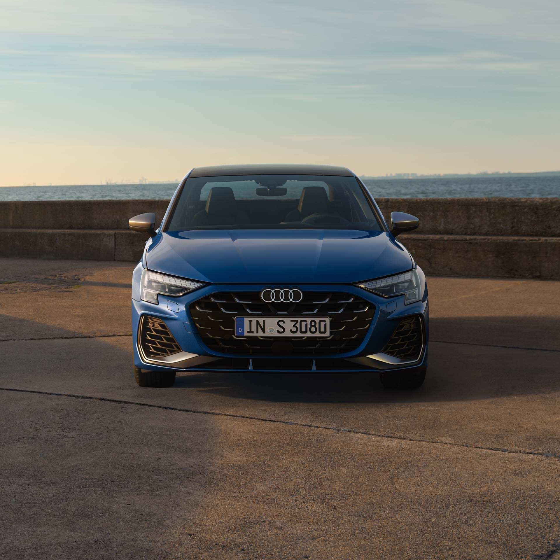 Audi S3 Limuzína z čelného pohľadu zaparkované na móle pri mori. V pozadí vidieť panorámu mesta.