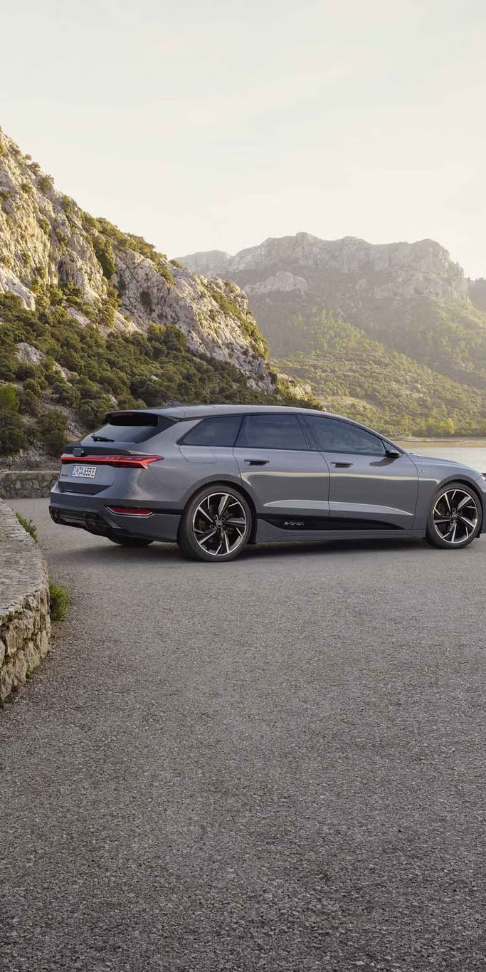 Ein grauer A6 Avant e-tron steht auf einem Platz vor einem Gewässer.