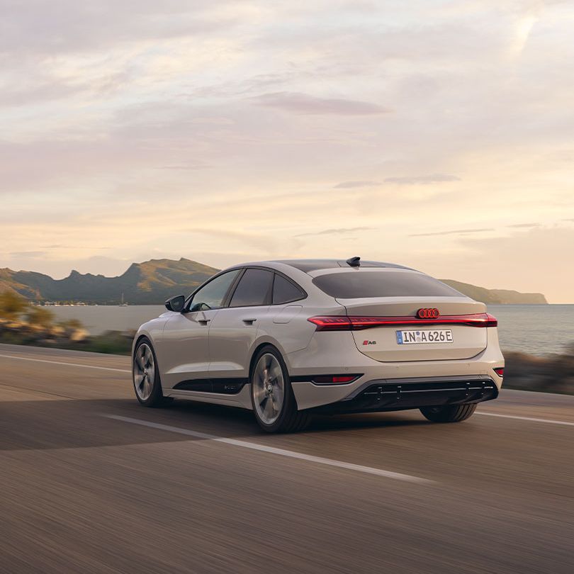 Audi A6 Sportback e-tron počas jazdy  popri pobreží.