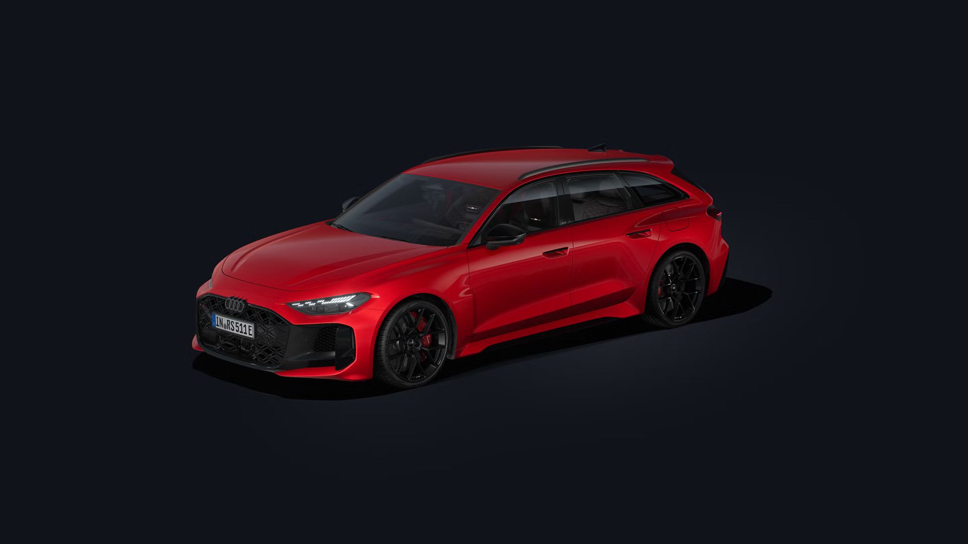 Červené Audi RS 5 Avant na čiernom pozadí pri pohľade šikmo spredu a boku.