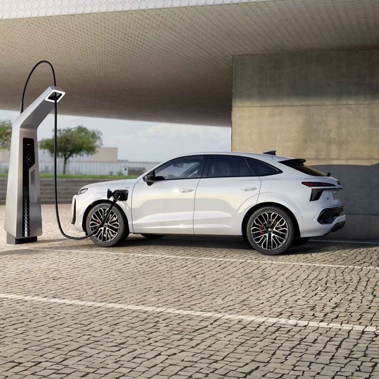 Bočný pohľad na Audi Q3 Sportback e-hybrid počas nabíjania.