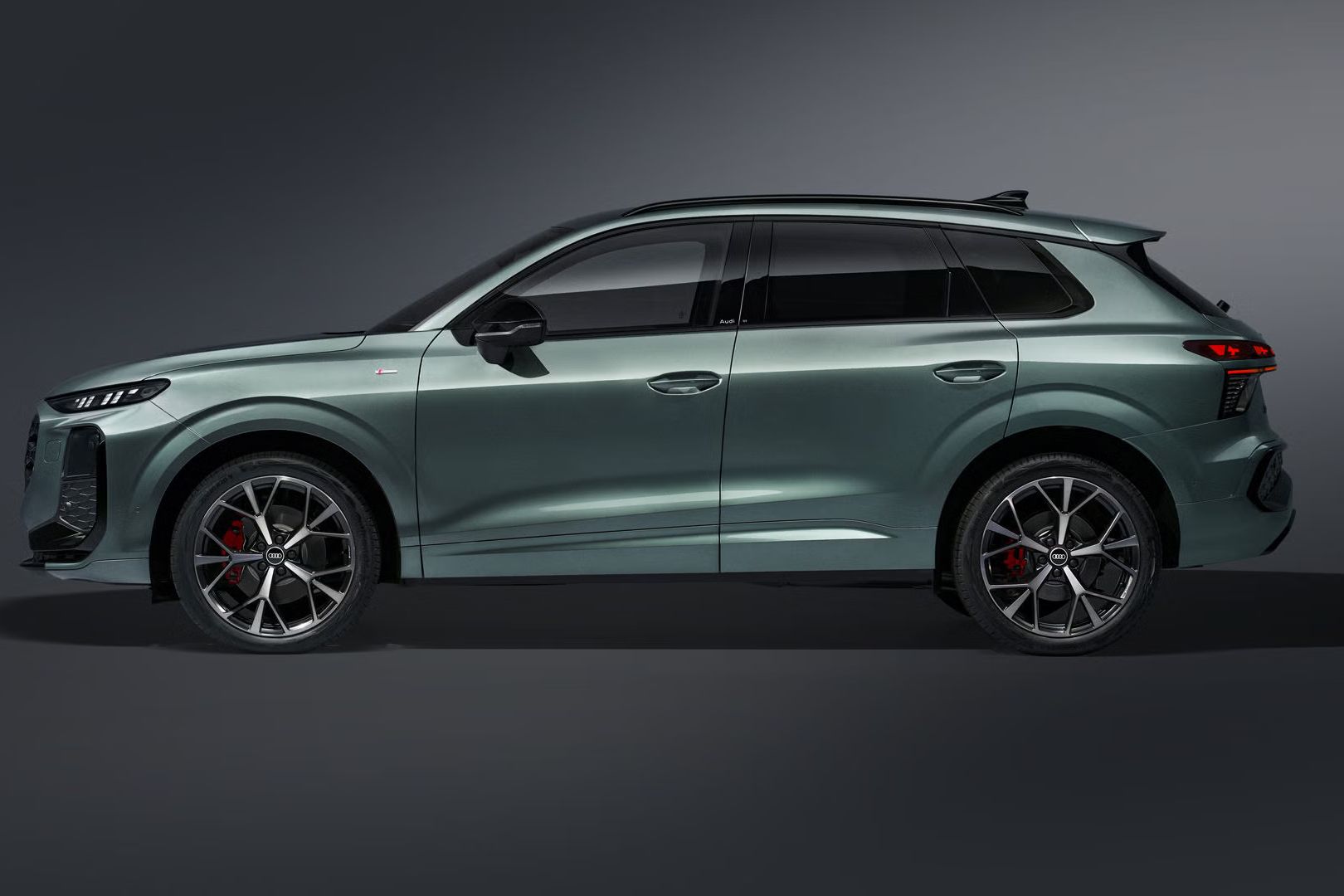 Audi Q3 SUV z bočného pohľadu na tmavom pozadí.