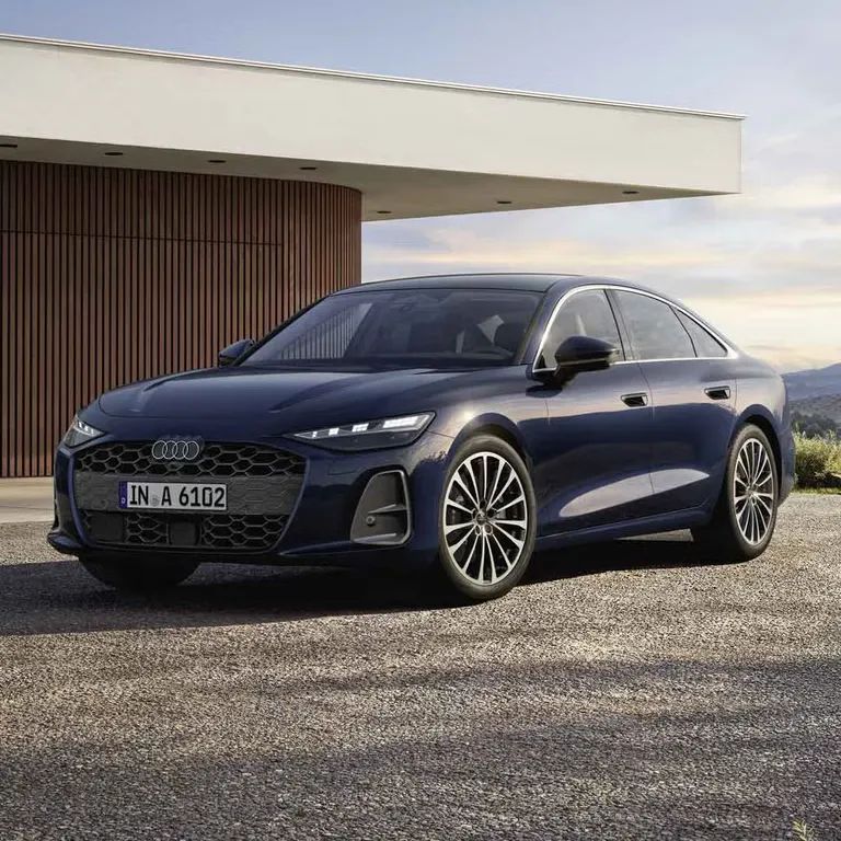 Audi A6 Limuzína stojí na štrkovom priestore pre modernou vilou.