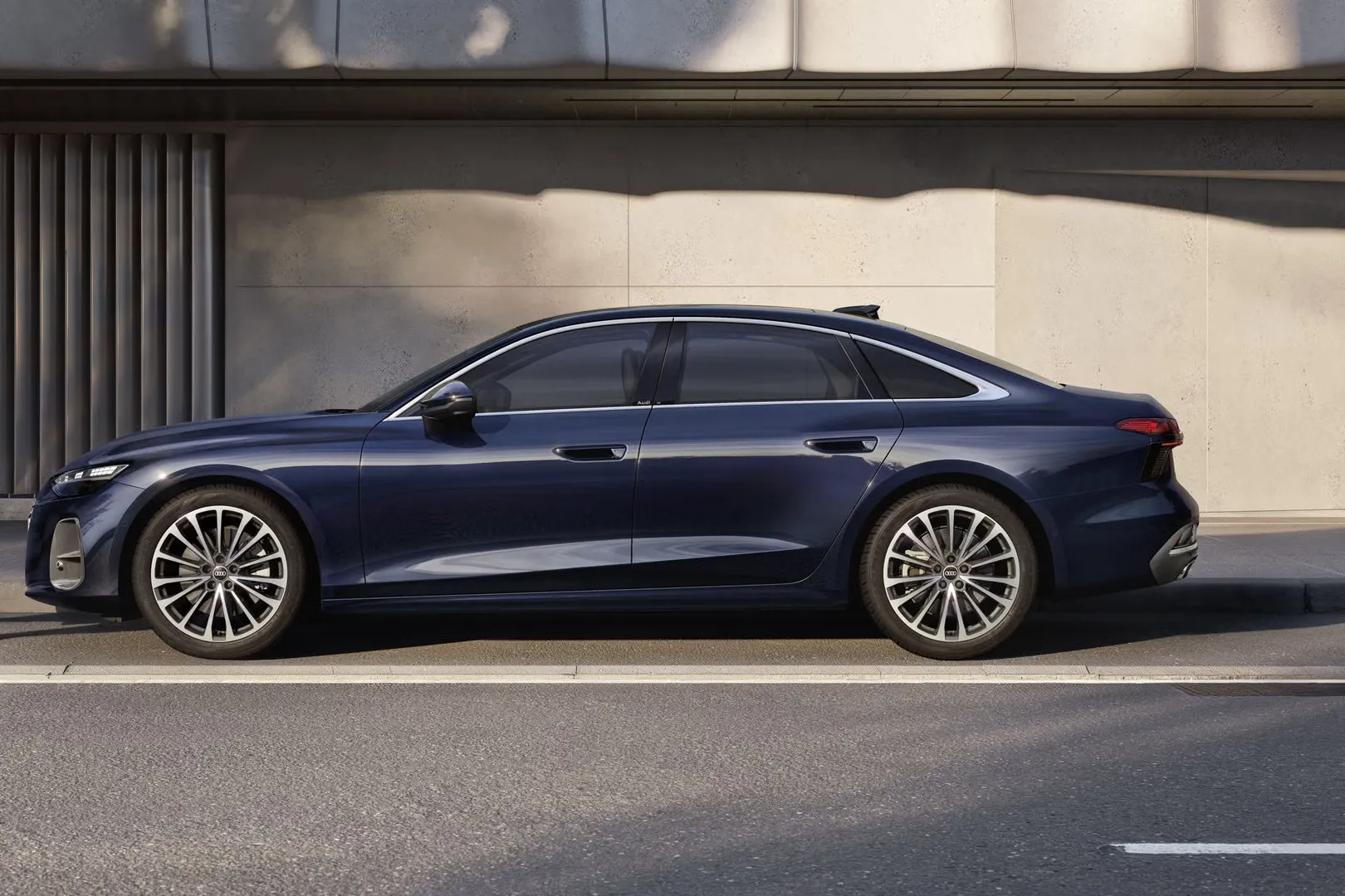 Modré Audi A6 Limuzína z bočného pohľadu zaparkované pri ceste vedľa modernej budovy.