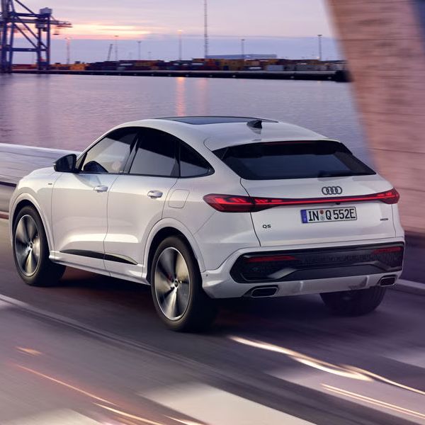 Pohľad na zadné partie Audi Q5 Sportback e-hybrid počas dynamickej jazdy popri pobreží.