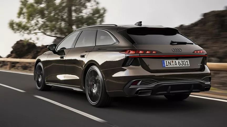 Audi A6 Avant zozadu počas jazdy na ceste v horskej krajine. Cestu lemujú skaly, zeleň a stromy.