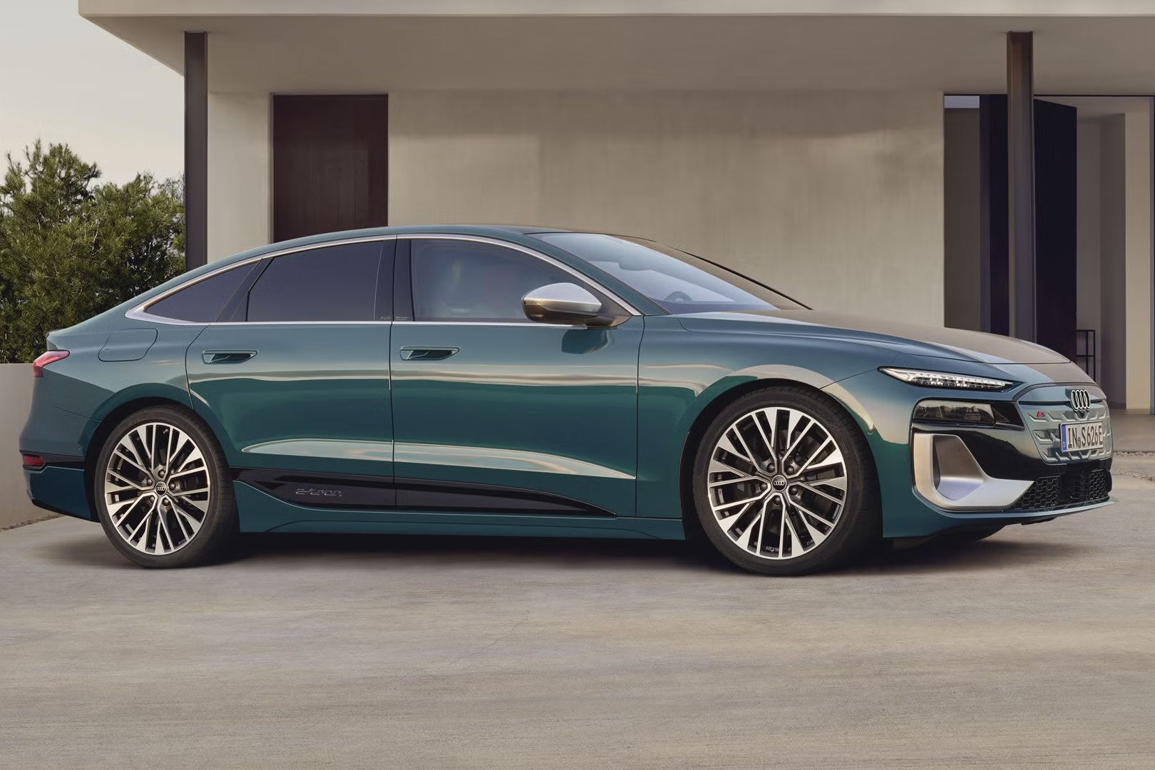 S6 Sportback e-tron stojí v mierne šikmom bočnom profile pred moderným domom.