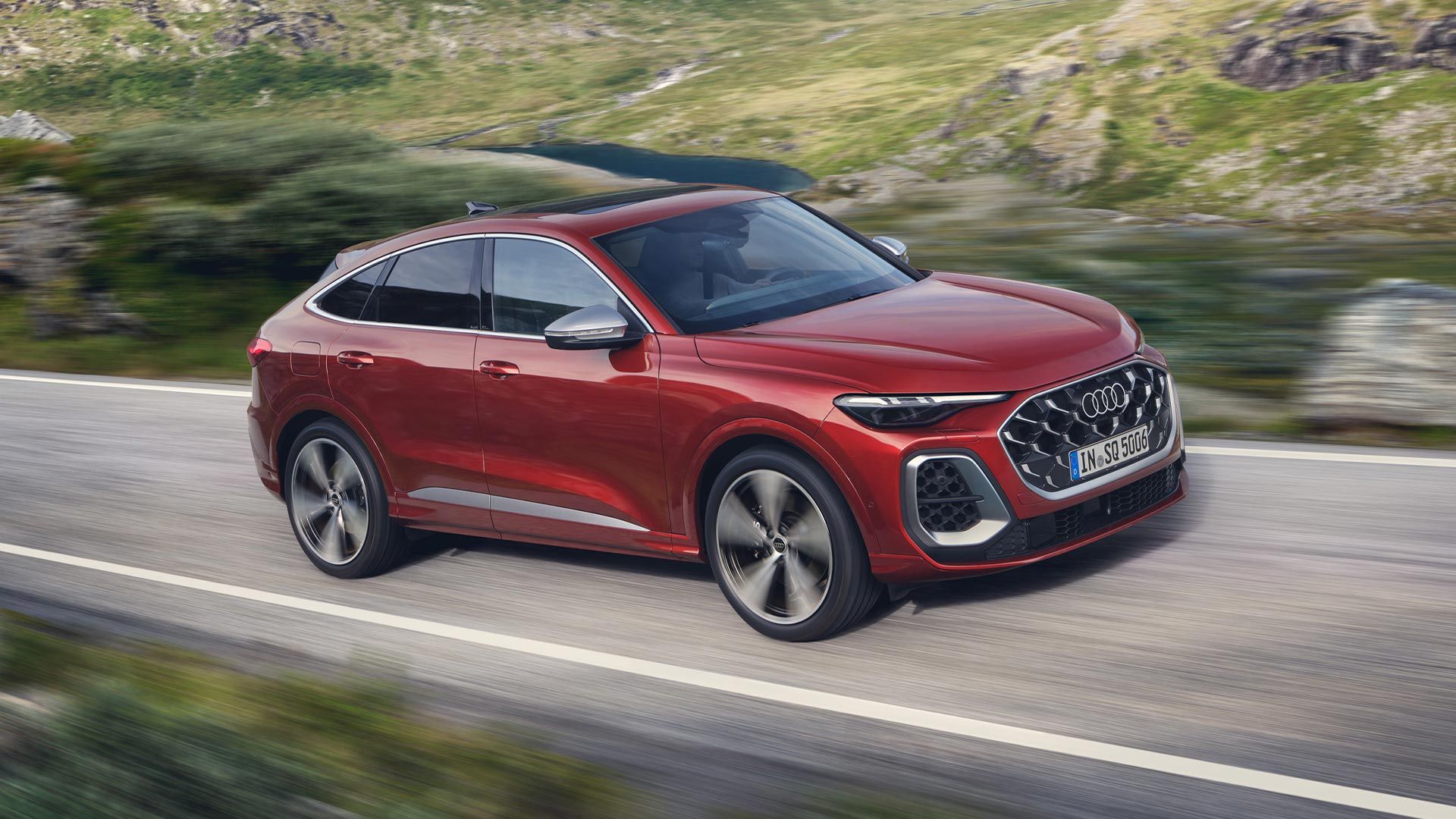 Bočný pohľad na jazdiace červené Audi SQ5 Sportback.