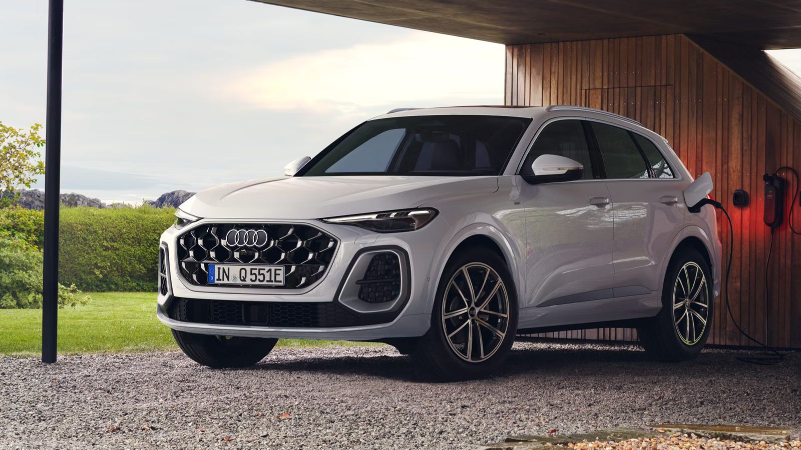 Audi Q5 SUV e-hybrid pred domom pripojený k domácej nabíjacej stanici.