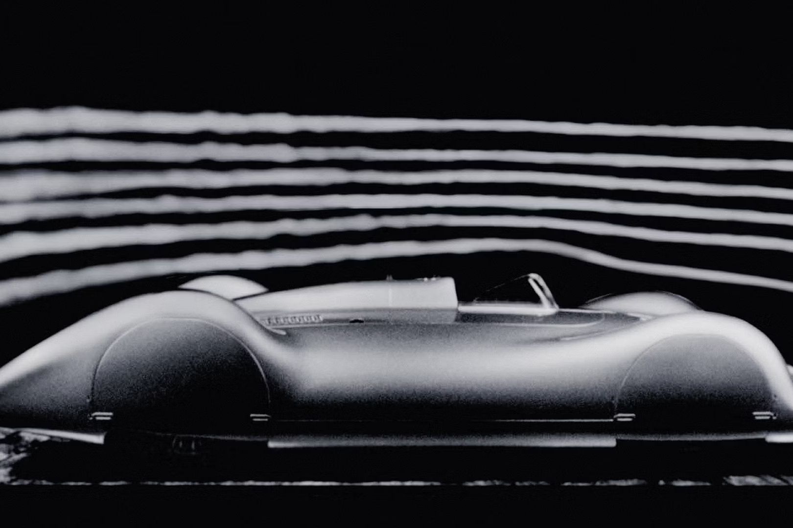 Historický model Audi počas aerodynamického testu, pri ktorom vidieť prúdenie vzduchu okolo vozidla.