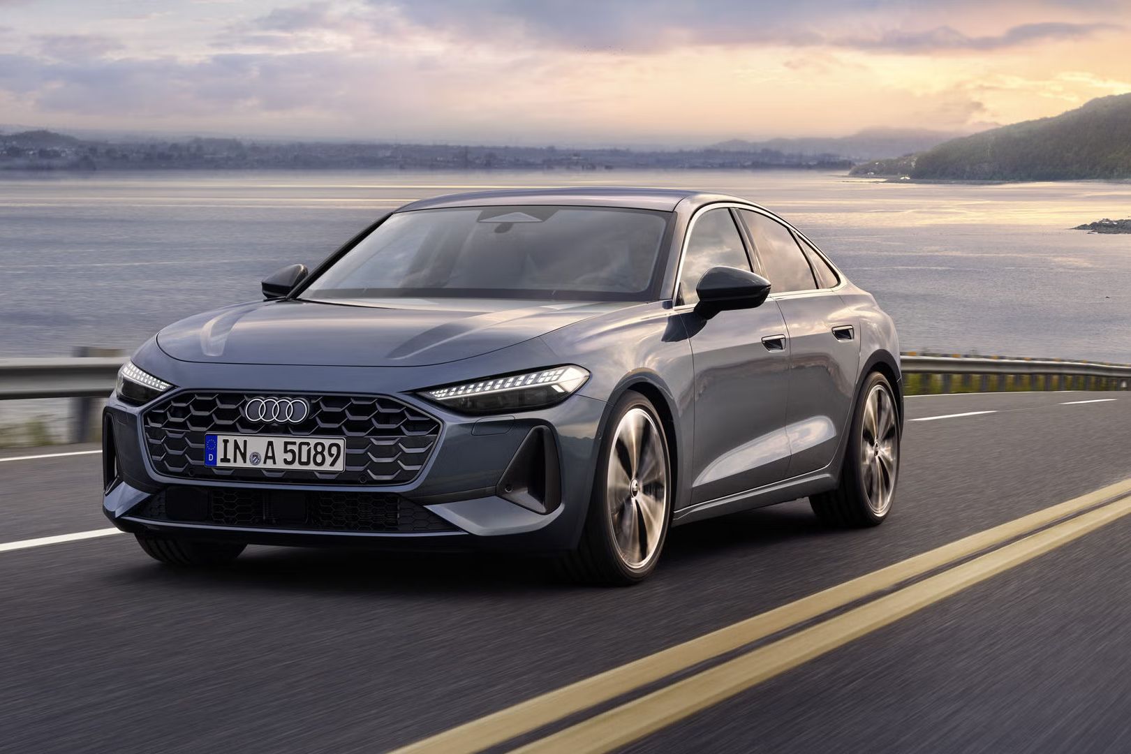 Pohľad na sivé Audi A5 Limuzína počas jazdy popri pobreží.