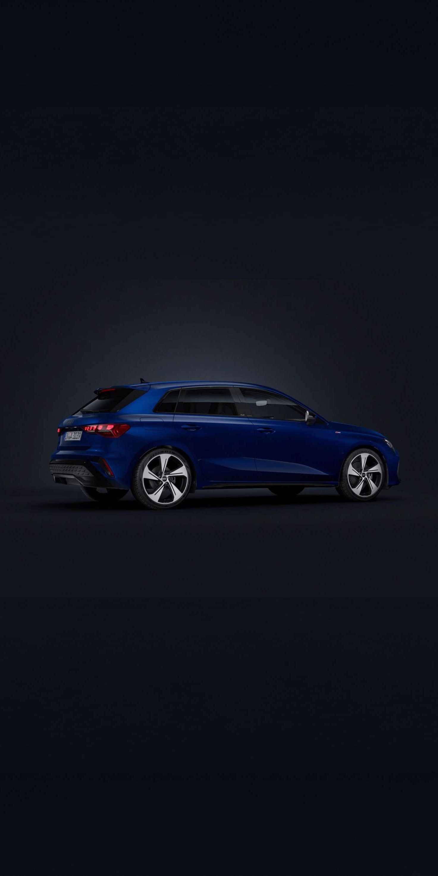 Modré Audi A3 Sportback zo zadného šikmého pohľadu na čiernom podklade.